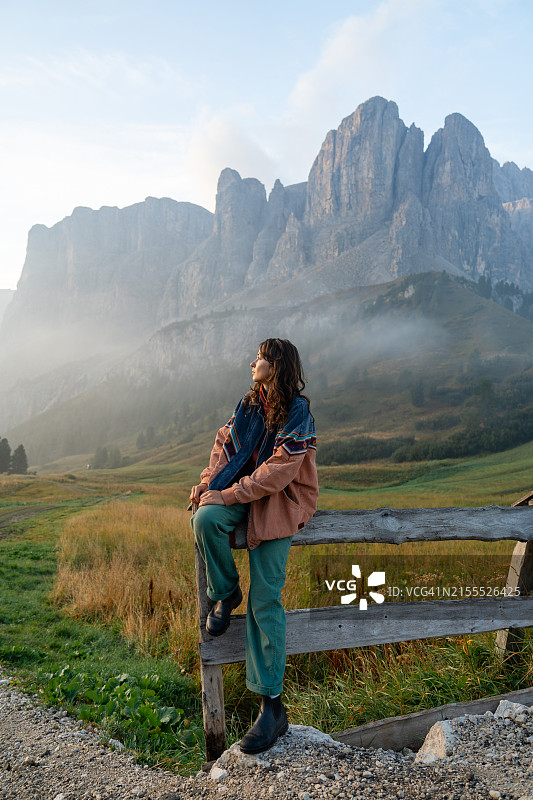 在瓦尔加尔德纳山峰背景下，坐着的女人图片素材