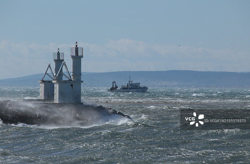 在米斯特拉尔风中卡马格港南通道入口处的两座灯塔-奥克西塔尼-加尔/法国图片素材