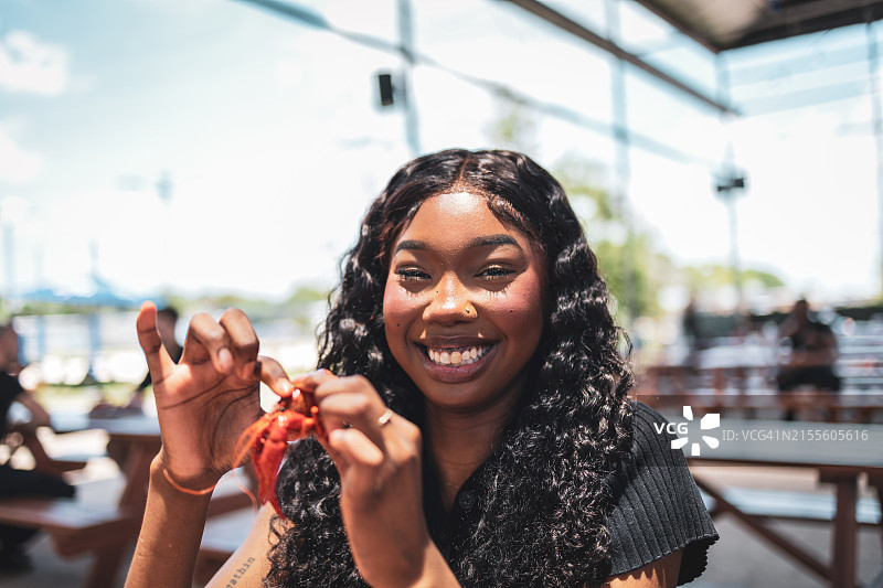 微笑的女人与朋友在户外用餐图片素材