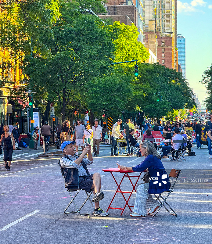 情侣坐在纽约市哥伦布大道中央，该路段已禁止通行图片素材