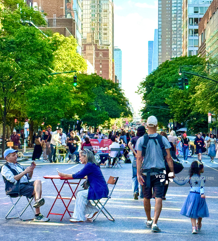 在纽约市哥伦布大道上步行和坐着的家庭图片素材