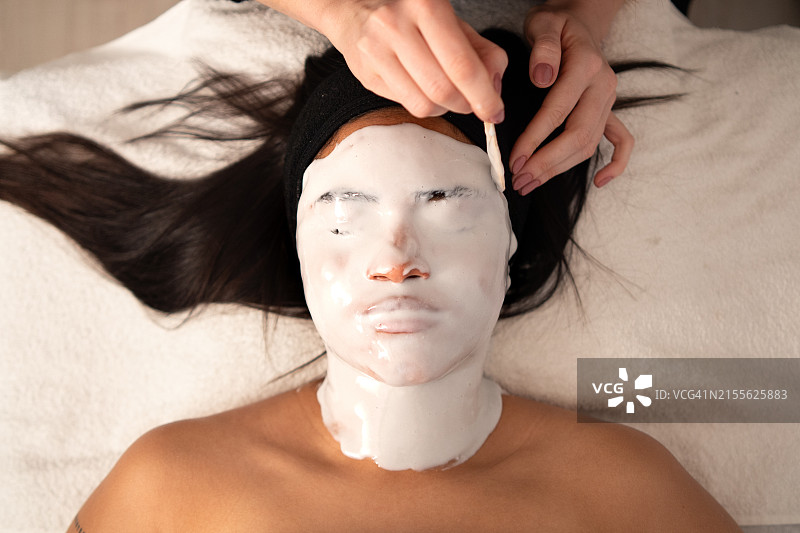 皮肤科医生在水疗中心用面膜遮盖患者的脸图片素材