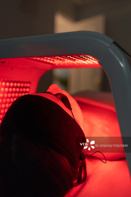 女人接受LED灯面膜再生治疗的特写图片素材