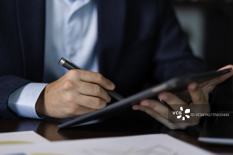 商人使用手写笔在平板电脑上签署数字合同图片素材