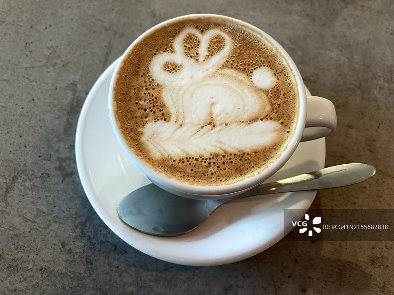 咖啡馆水泥桌面上的兔子拉花馥芮白咖啡图片素材