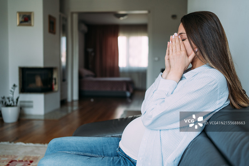 沮丧的年轻孕妇在家中图片素材