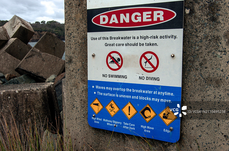 澳大利亚新南威尔士州Ulladulla港防波堤上的安全警告标志图片素材