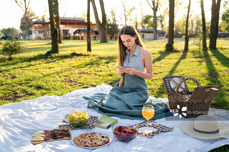 阳光明媚的野餐日，美丽的年轻女子图片素材