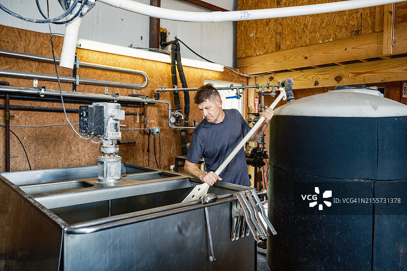 中年威士忌酿酒师在酿酒厂工作图片素材