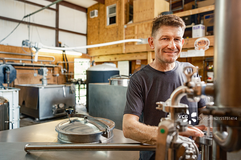 中年威士忌酿酒师在酿酒厂工作图片素材