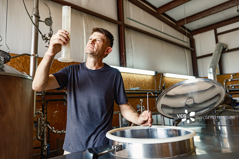 中年威士忌酿酒师在酿酒厂工作图片素材