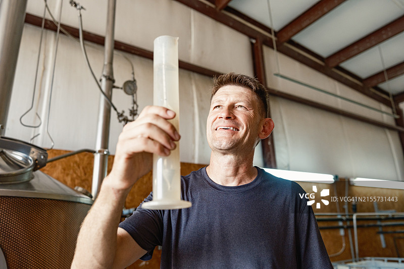 中年威士忌酿酒师在酿酒厂工作图片素材