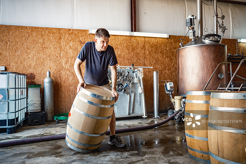中年威士忌酿酒师在酿酒厂工作图片素材