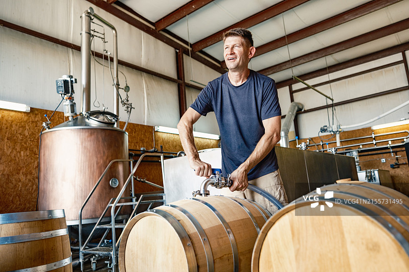 中年威士忌酿酒师在酿酒厂工作图片素材