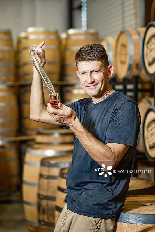 中年威士忌酿酒师在酿酒厂酒吧品尝威士忌图片素材
