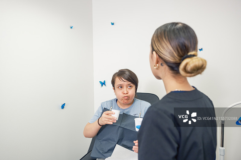 年轻的墨西哥女技师在牙齿美白沙龙与女客户在一起图片素材