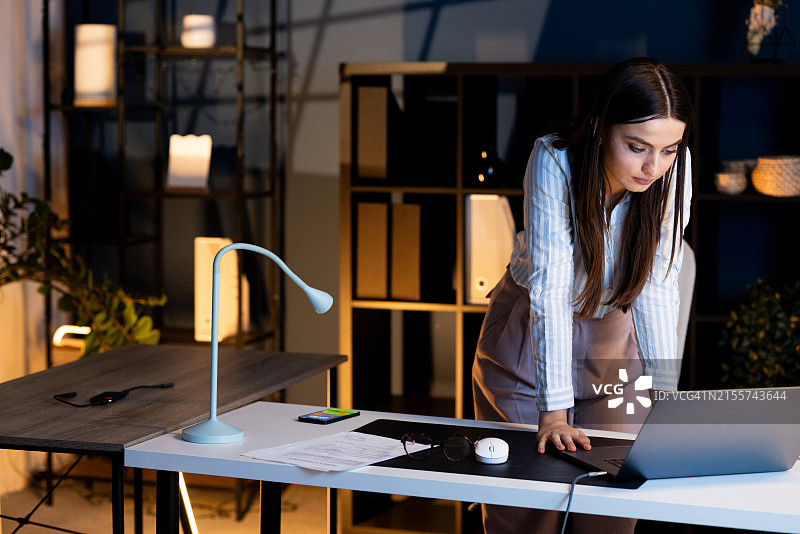 夜晚在家办公的年轻女人图片素材