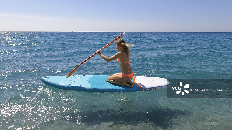 年轻女子在海上玩桨板图片素材