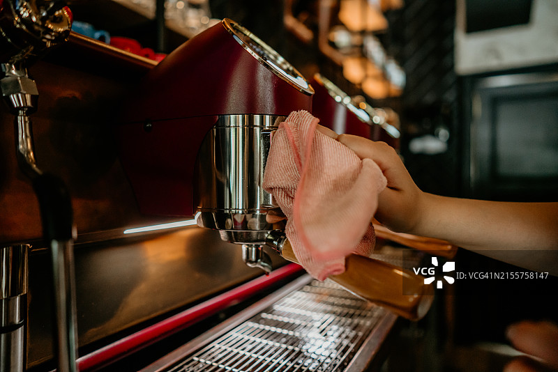 年轻女子清洁机器，咖啡馆女服务员在室内工作图片素材