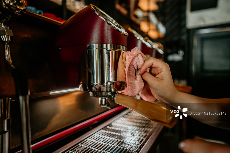 年轻女子清洁机器，咖啡馆女服务员在室内工作图片素材