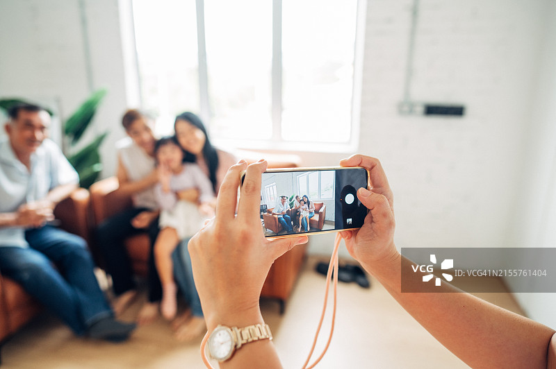 幸福的亚洲家庭用智能手机拍摄全家福图片素材