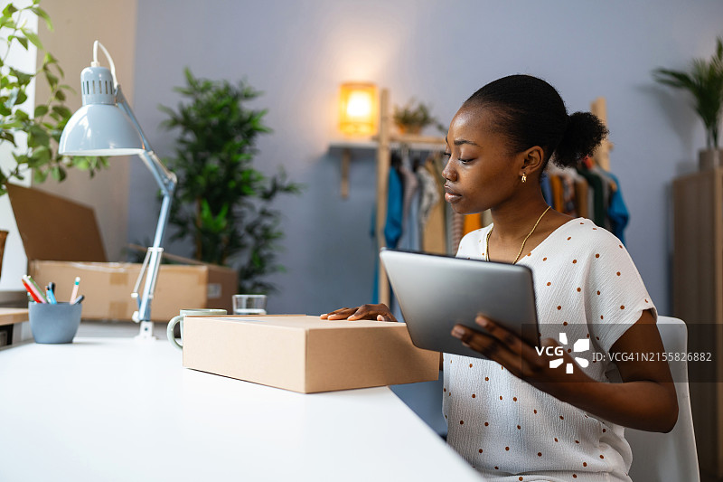 黑人女小企业主准备包裹发货图片素材