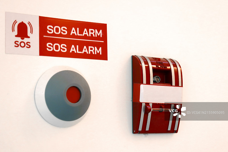 办公楼混凝土墙上的红色火灾报警开关，工业火灾紧急警告系统设备图片素材