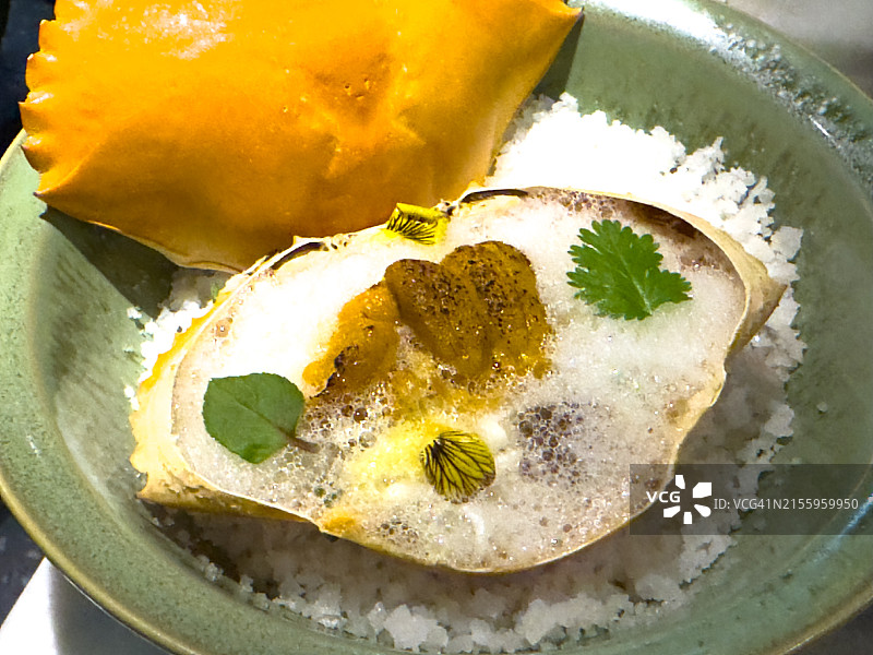 精致的螃蟹和海胆开胃菜配泡沫酱和新鲜香草图片素材