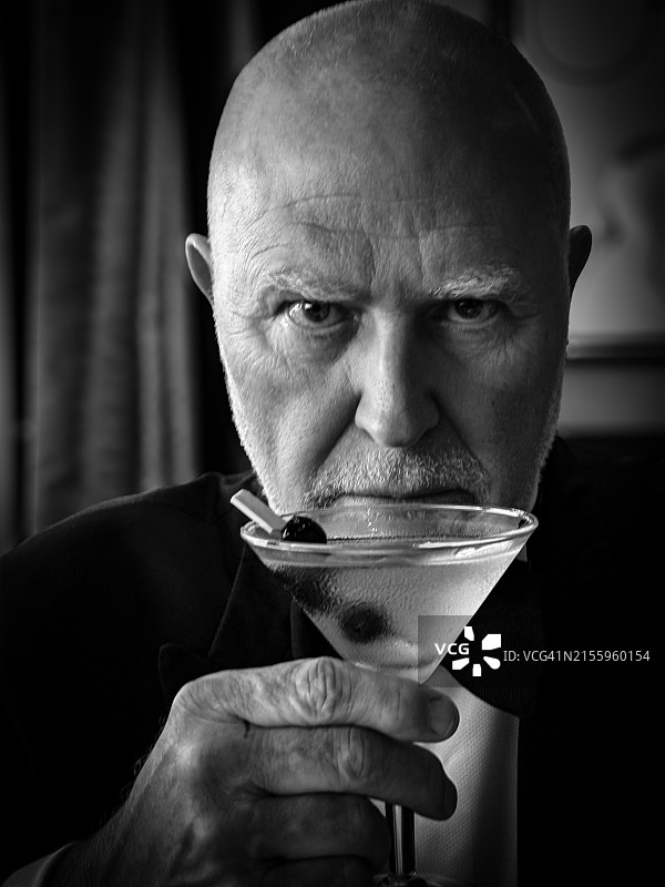 手持马提尼酒的燕尾服男子图片素材