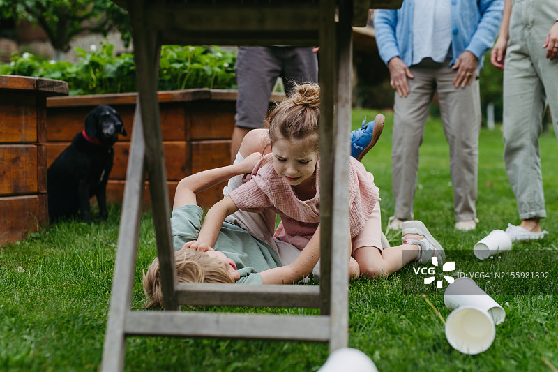 户外家庭游戏中争吵躺在地上的兄弟姐妹图片素材