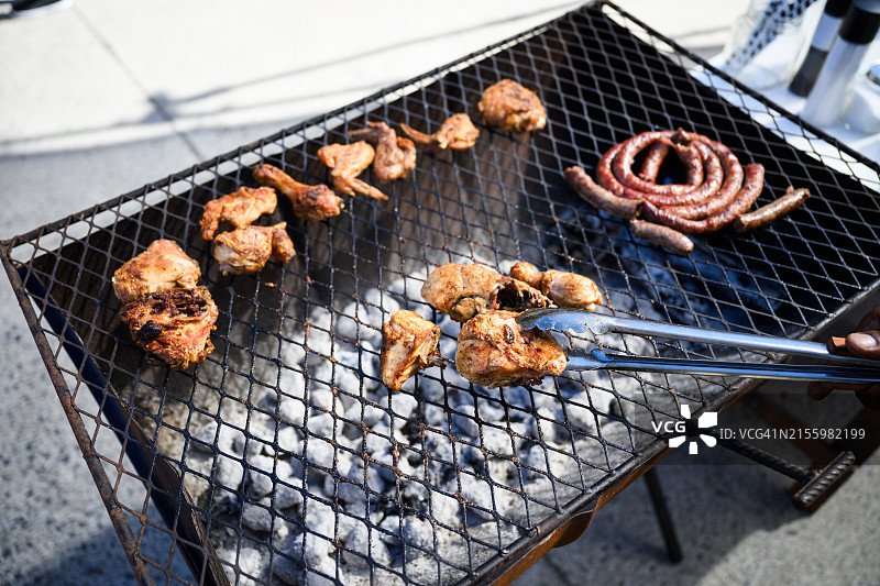 半钢制桶式烧烤架与鸡肉和香肠图片素材