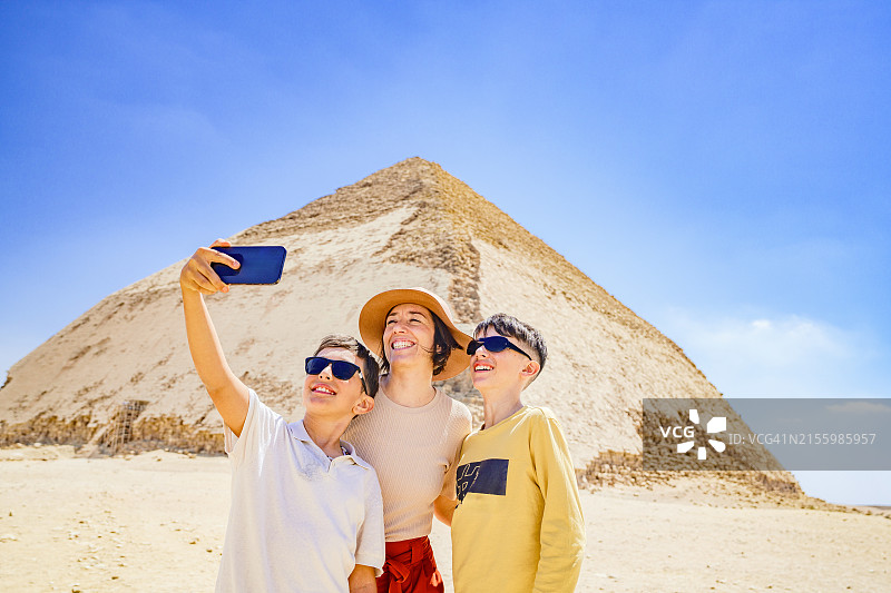 快乐的男孩和母亲在弯曲金字塔前自拍图片素材