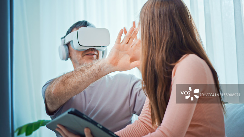 祖父和少女在客厅里玩VR眼镜图片素材