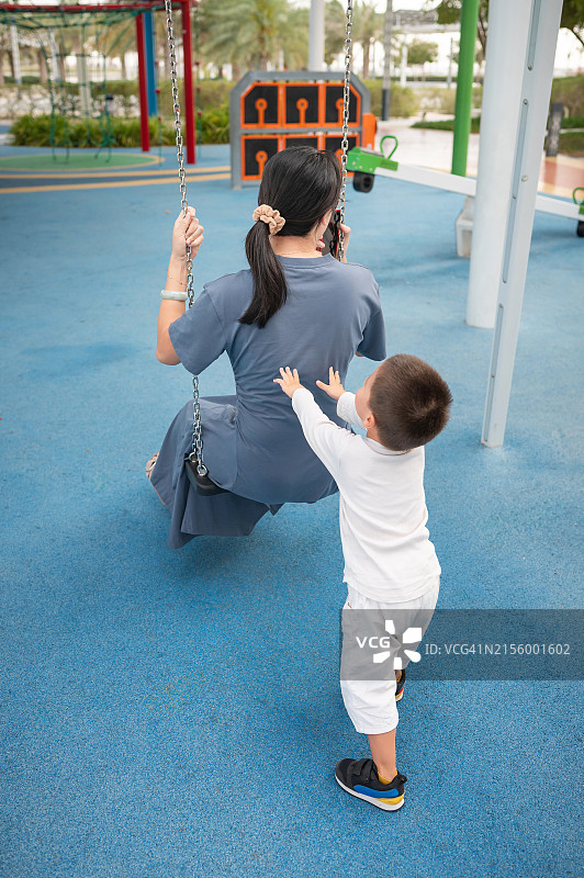 母亲和幼儿儿子在公园里玩耍图片素材