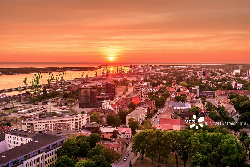 夏季日落时克莱佩达港口的起重机和城市景观航拍图片素材