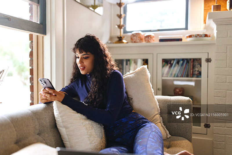 女人在客厅用智能手机打字图片素材
