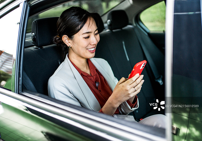 坐在车里使用手机的商务女人图片素材