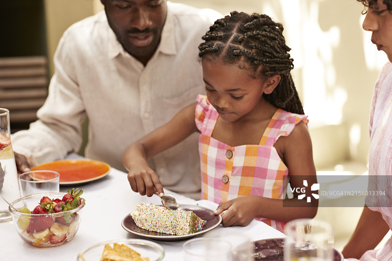 女孩和父母一起吃生日蛋糕图片素材