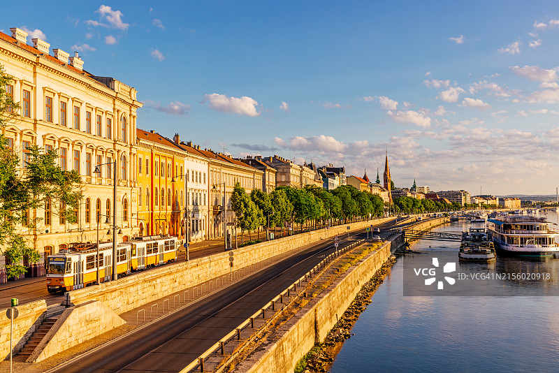 匈牙利布达佩斯晴朗的早晨，多瑙河岸边的黄色电车和城市天际线图片素材