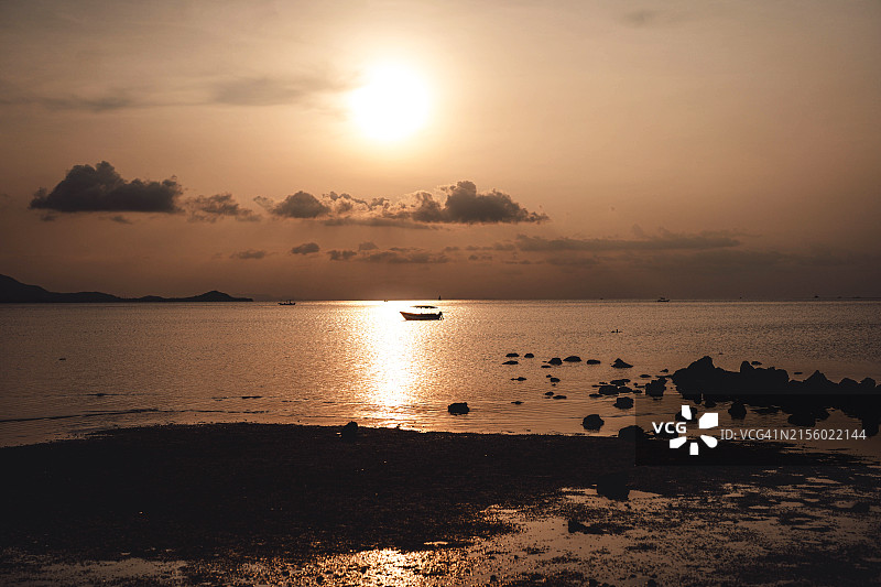 夕阳下的金色海面与渔船图片素材