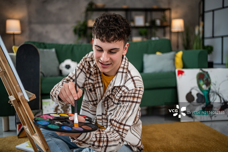 年轻男人在客厅绘画图片素材