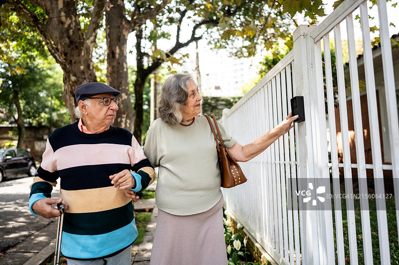 年长夫妇按响房子的门铃图片素材