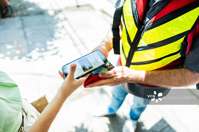 顾客在户外用手机支付特写图片素材
