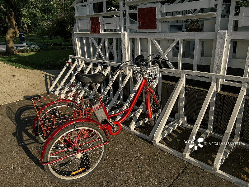 电动三轮车停靠在小型咖啡馆旁，配有自行车篮图片素材