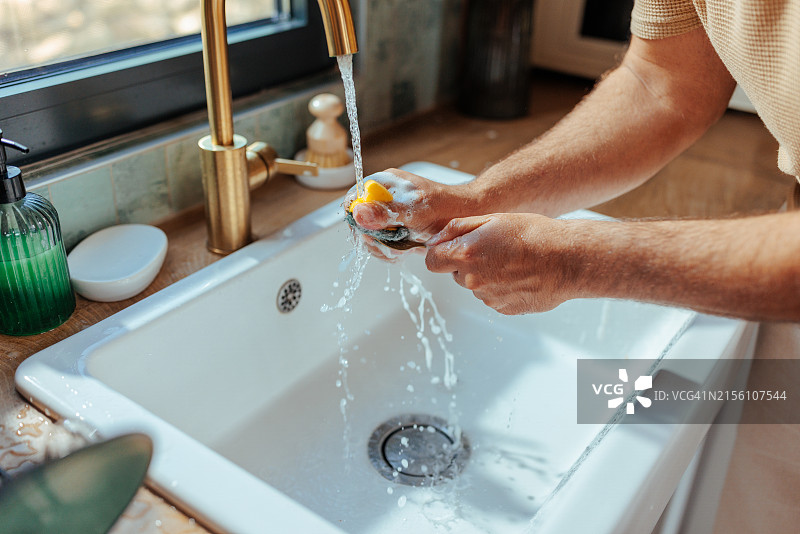 男子在厨房水槽清洗叉子的特写镜头图片素材