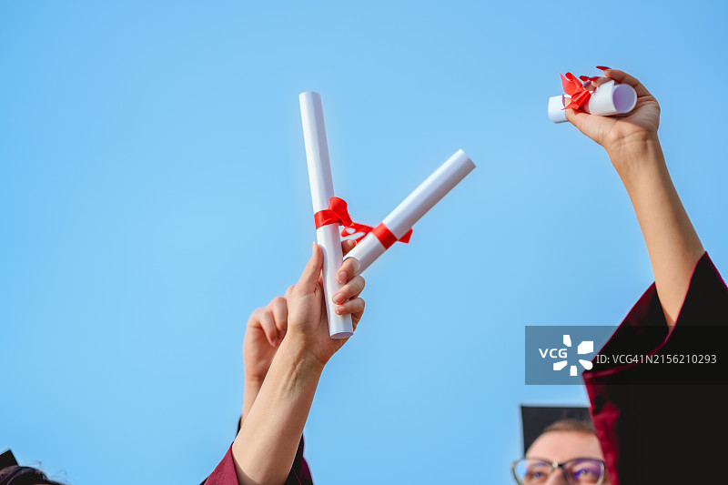 一群大学毕业生将文凭抛向空中图片素材