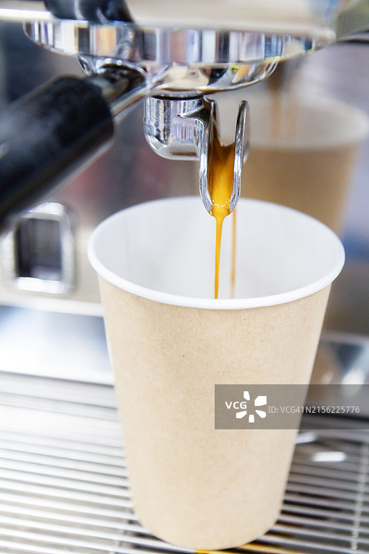 专业咖啡机将浓缩咖啡注入纸杯图片素材