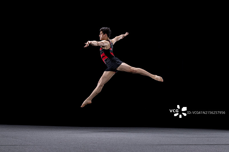 男子体操运动员在自由体操中跳跃图片素材