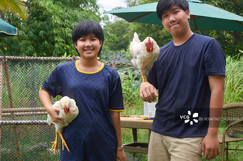 青少年和他们的鸡在鸡舍前图片素材