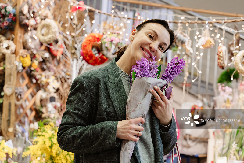 女人在市场上购买春季鲜花图片素材